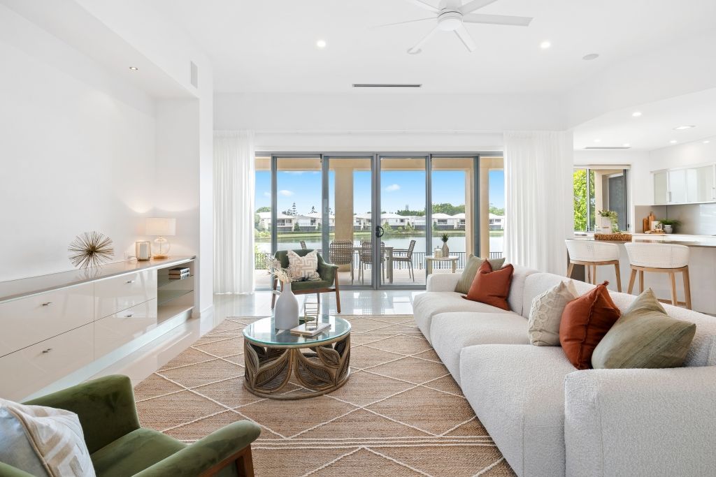 A living room with a couch , chair , coffee table and sliding glass doors.