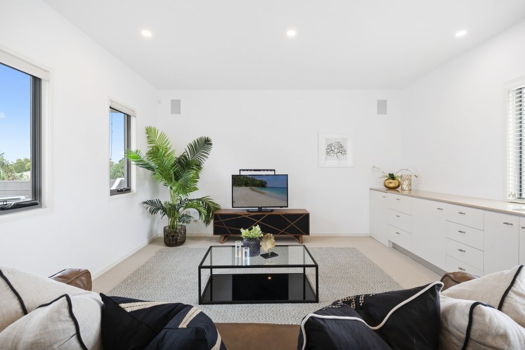 A living room with a couch , coffee table , and television.