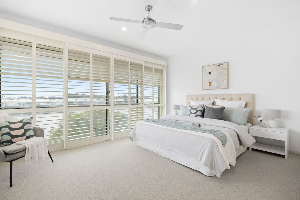 A bedroom with a large bed and a ceiling fan