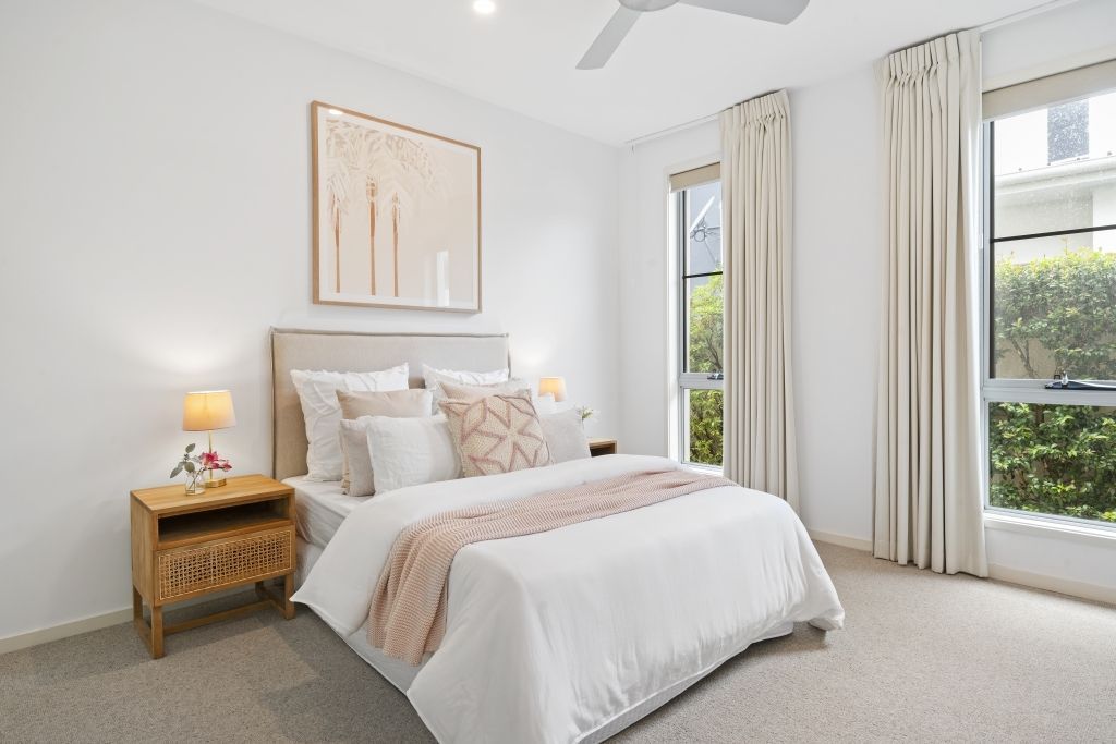 A bedroom with a large bed and a ceiling fan.