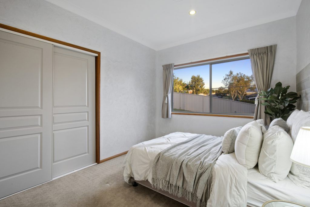 A bedroom with a large bed and a window.