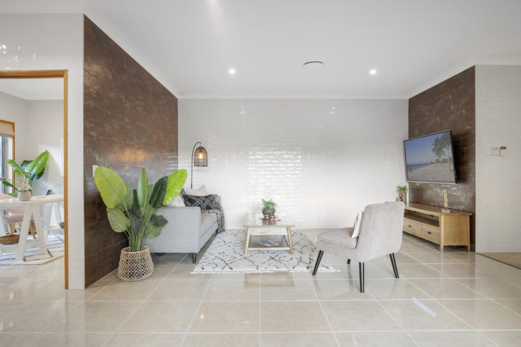A living room with a couch , chairs , table and television.
