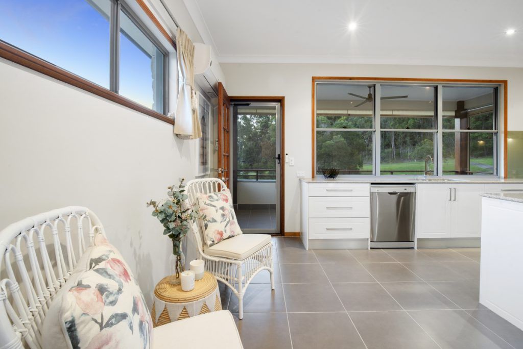 A living room with two chairs , a table and a window.