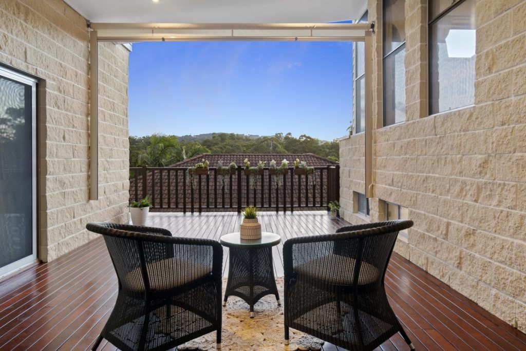 A wooden deck with wicker chairs and a table