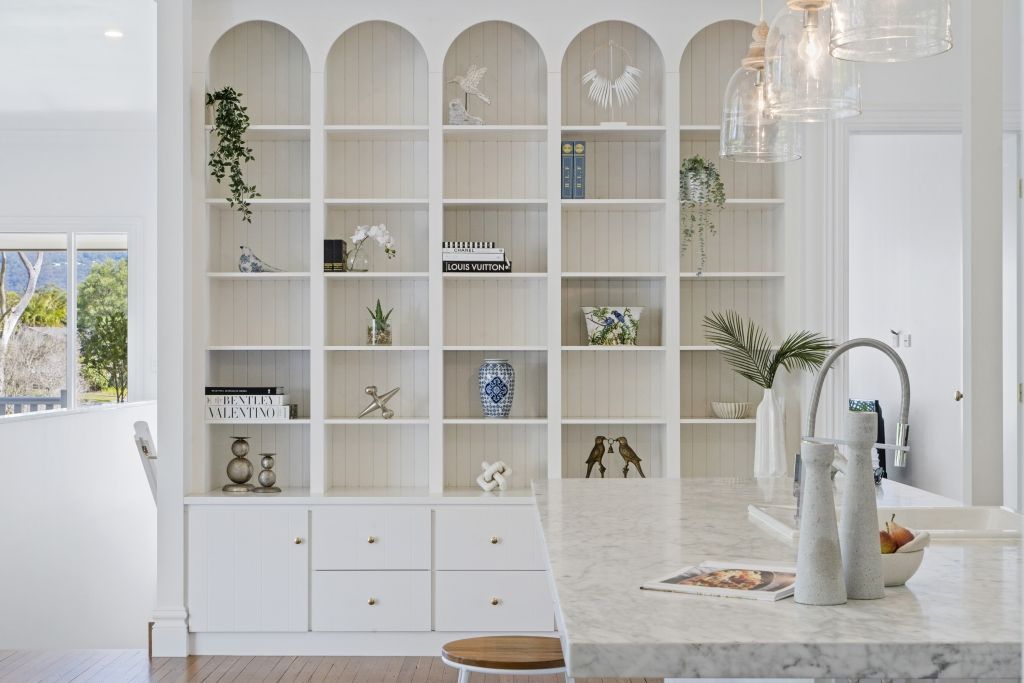 A kitchen with a lot of shelves and a sink.