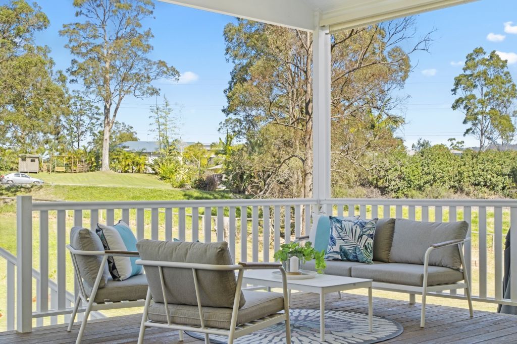 There is a porch with a couch and chairs on it.