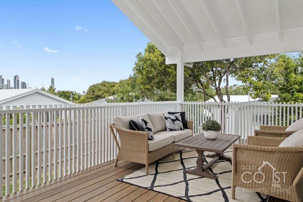 A deck with a couch , chairs , and a coffee table.