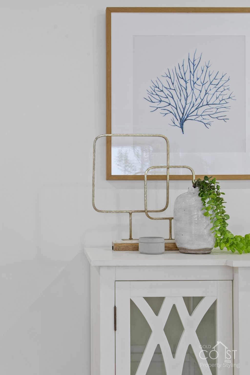 There is a picture of a tree on the wall above the cabinet.