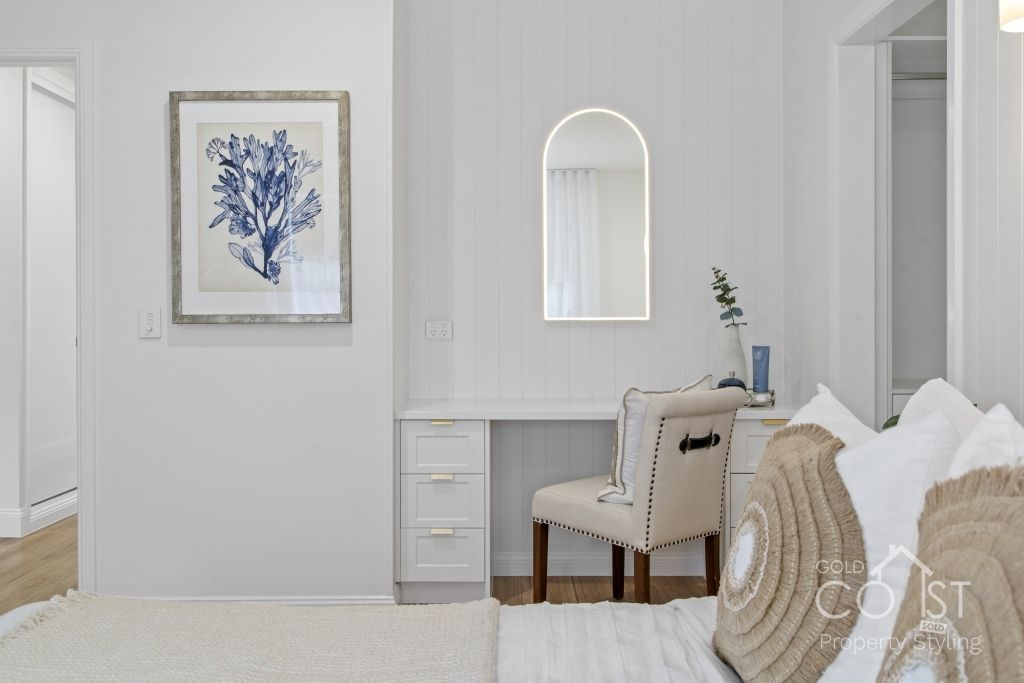 A bedroom with a bed , chair , desk and mirror.