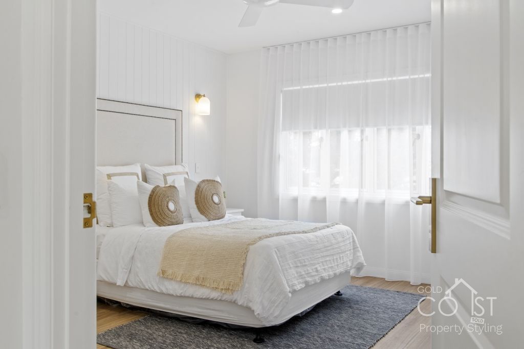 A bedroom with a bed , curtains , and a window.