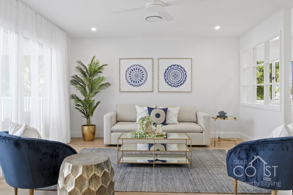 A living room with a couch , chairs , coffee table and a ceiling fan.