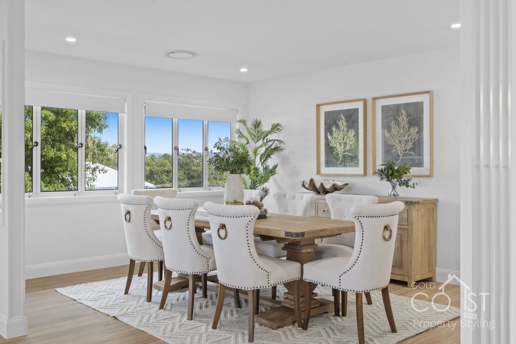 A dining room with a table and chairs and a rug.