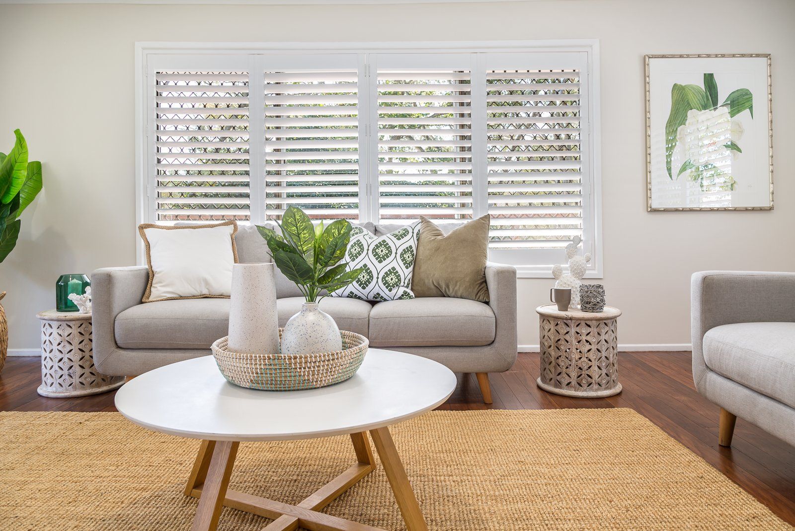 A living room with a couch , chair , coffee table and rug.