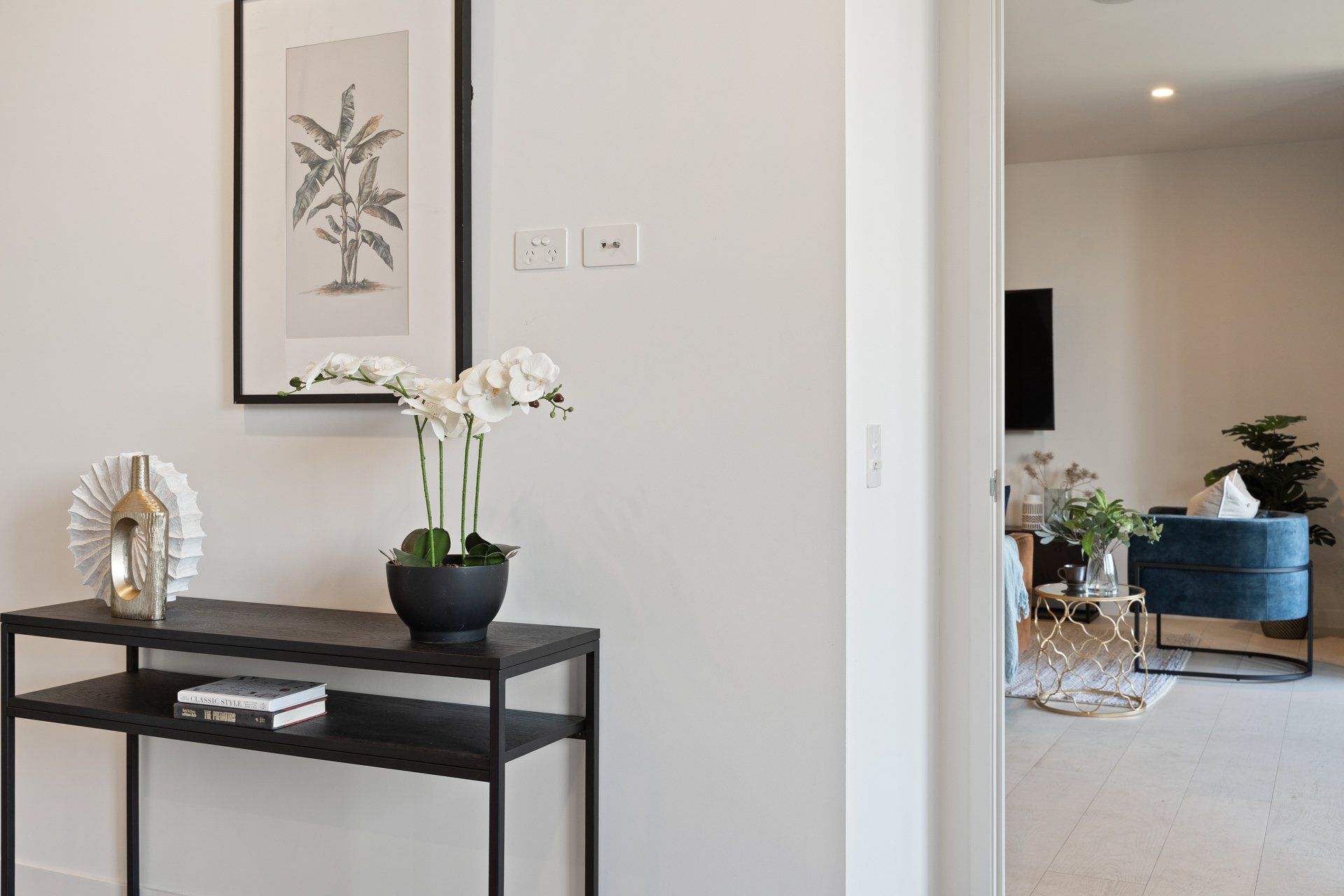 A hallway with a table and a picture on the wall.