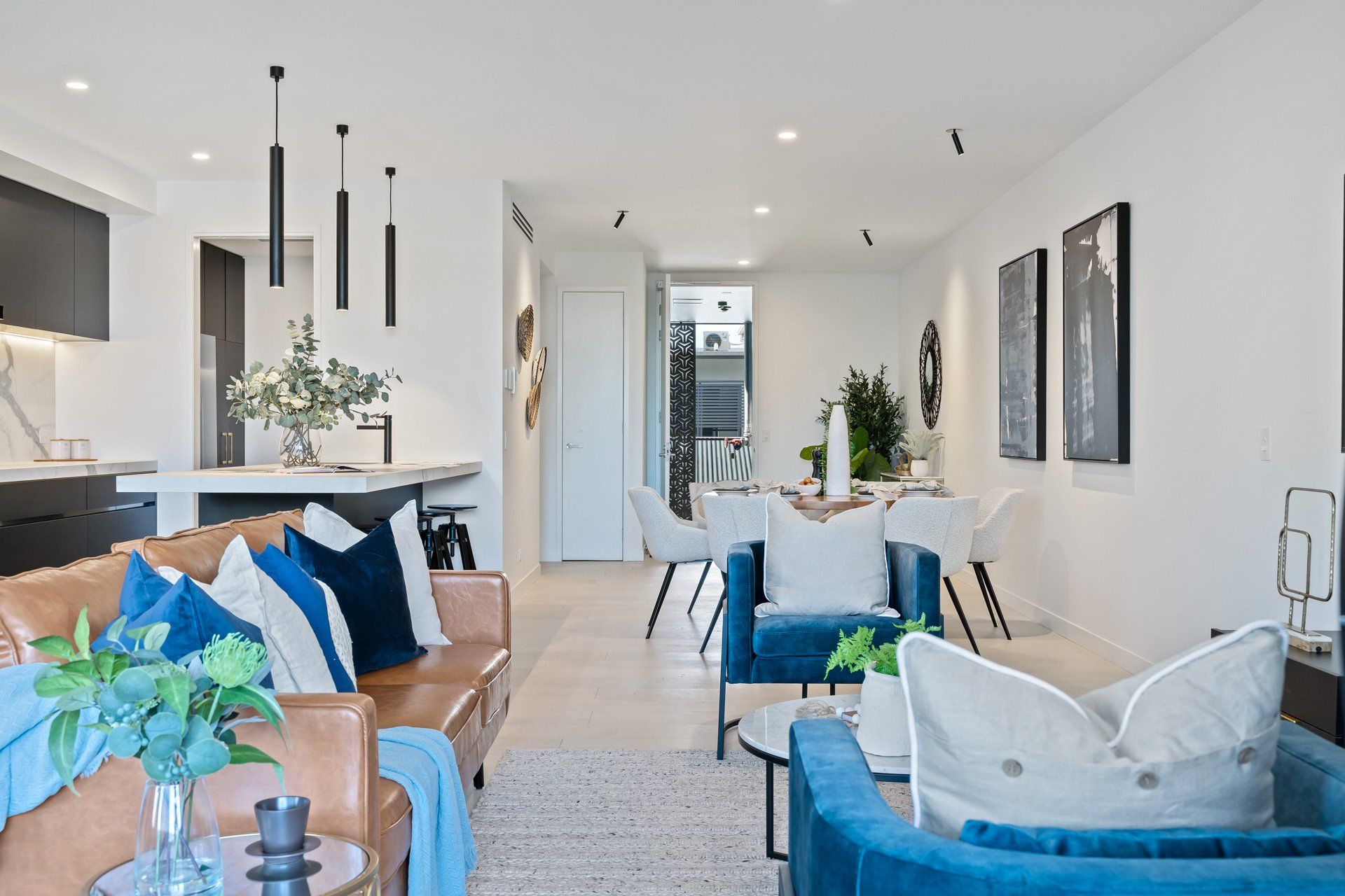 A living room with a couch , chairs , and a table.