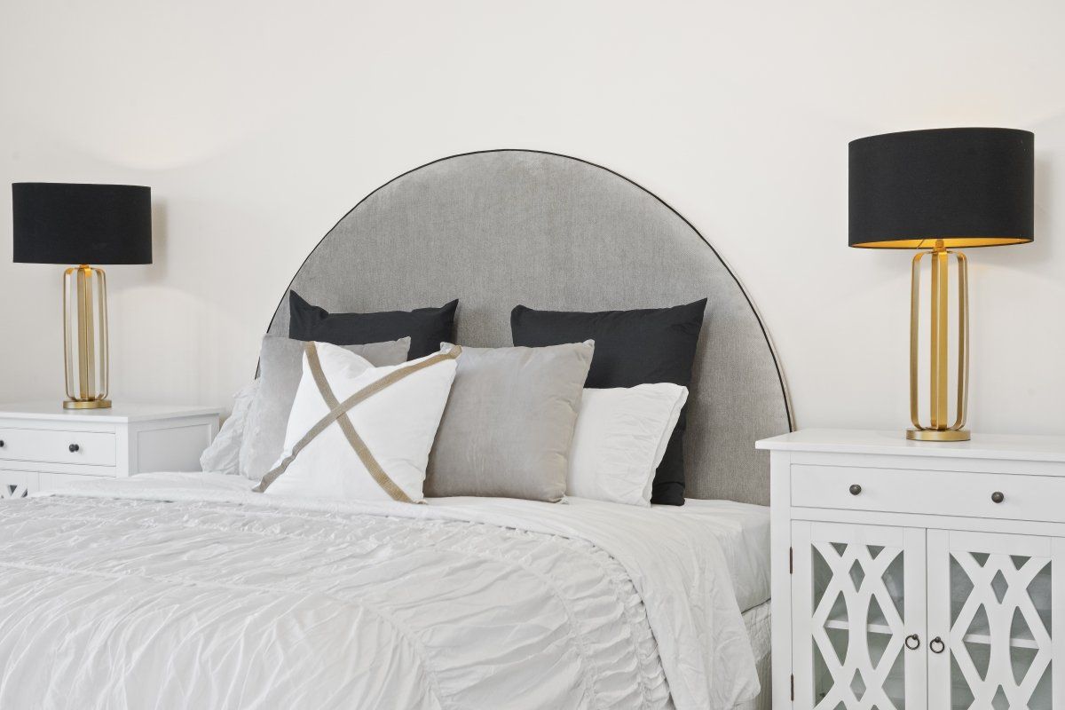 A bedroom with a bed , two nightstands and two lamps.