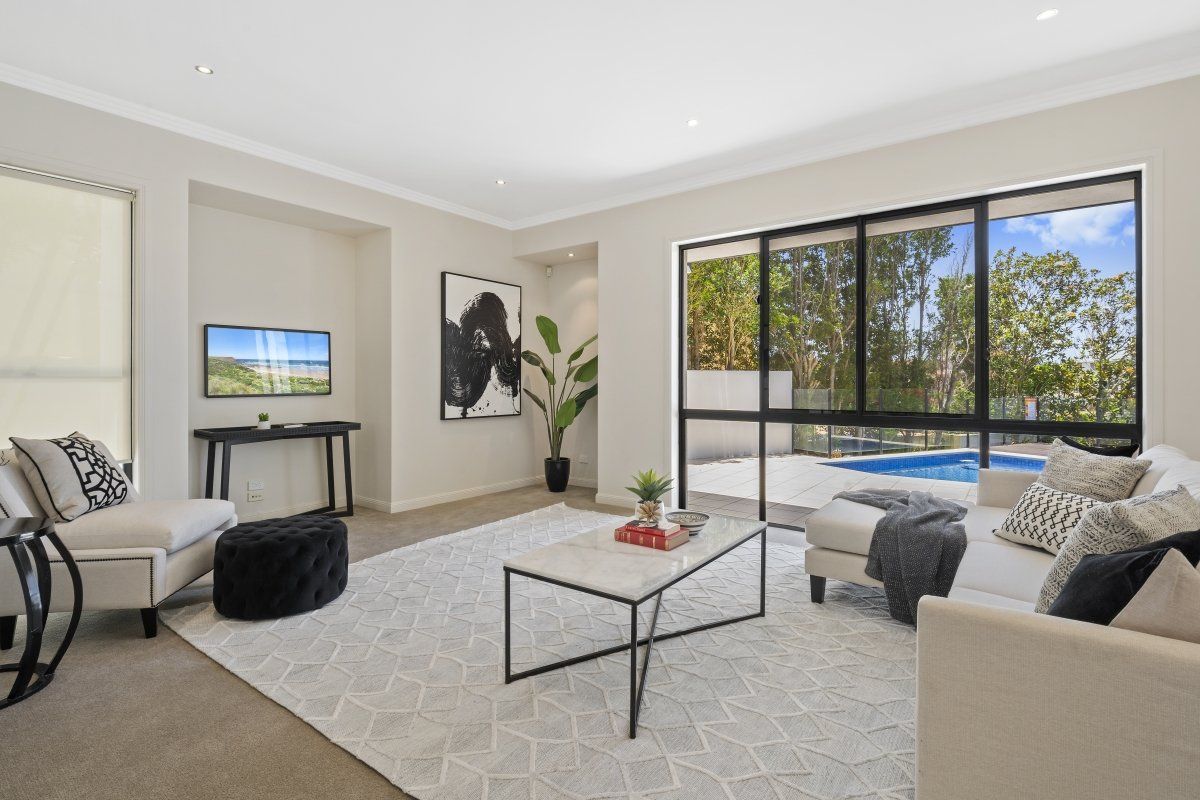 A living room with a couch , chair , coffee table and television.