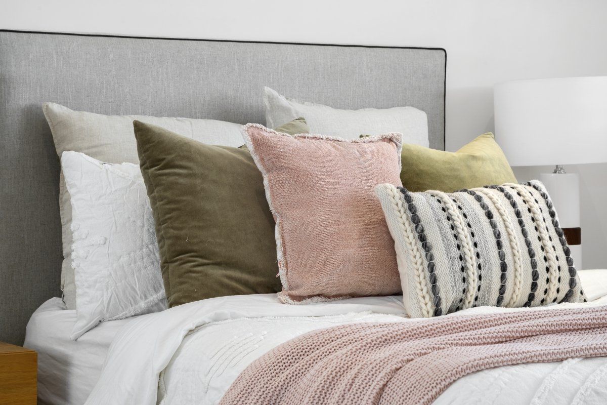 A bed with white sheets and pillows on it