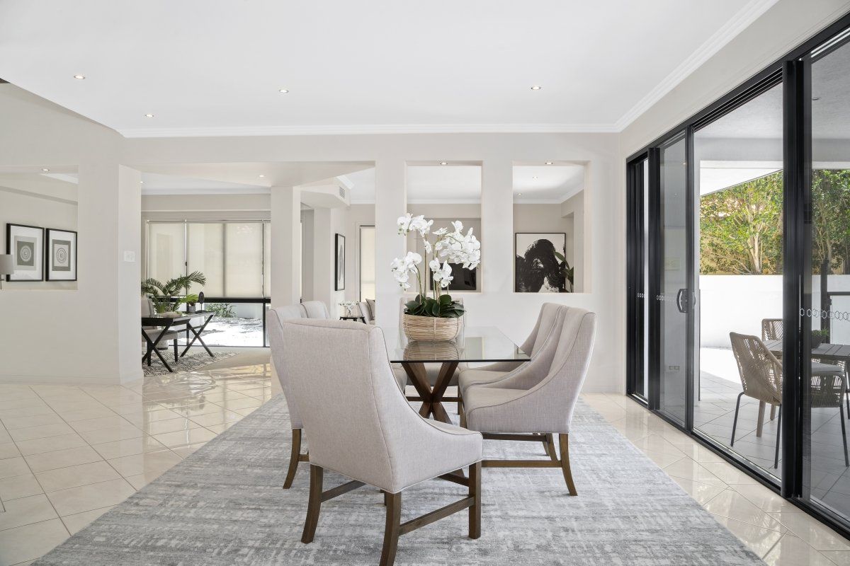 A dining room with a table and chairs and sliding glass doors.