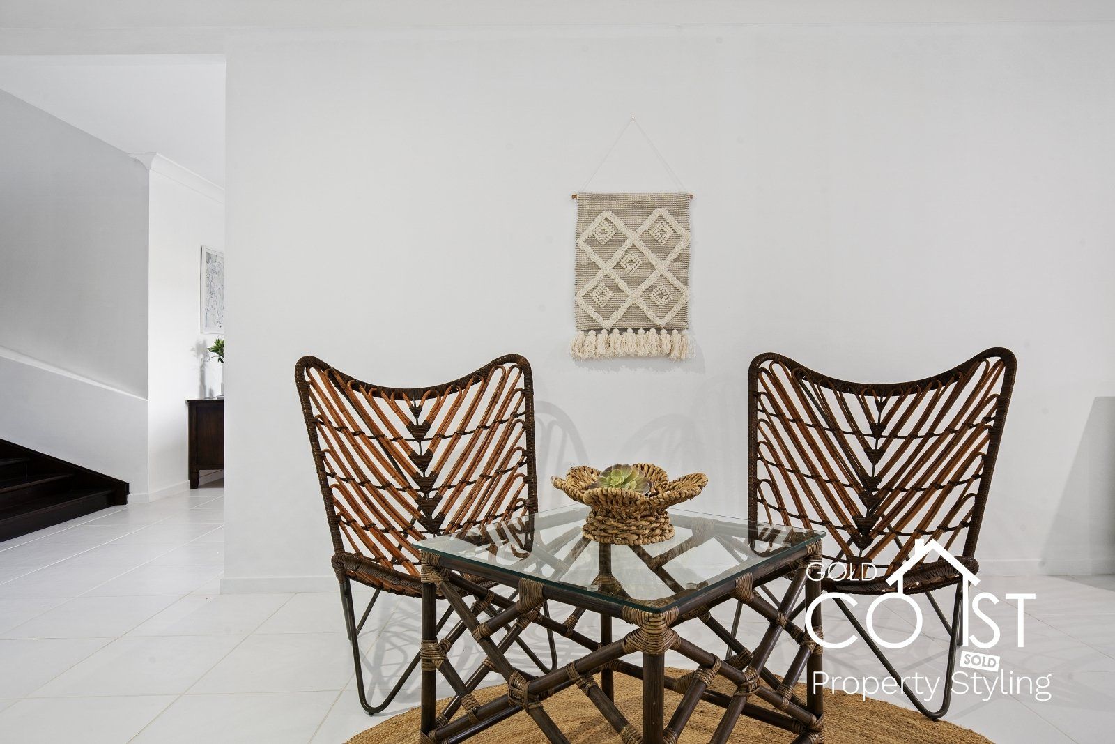 A dining room with a glass table and two chairs.