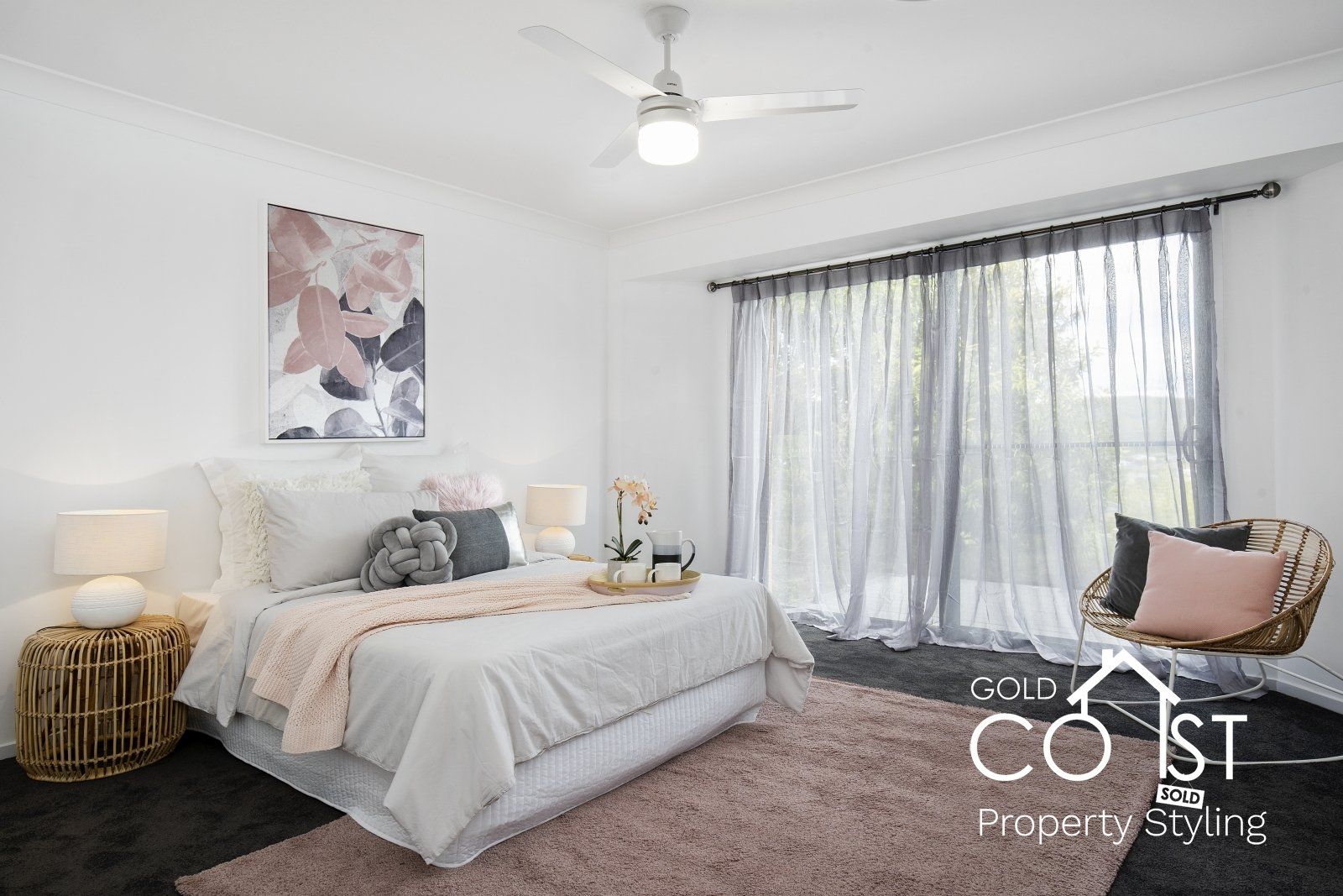 A bedroom with a large bed and a ceiling fan.