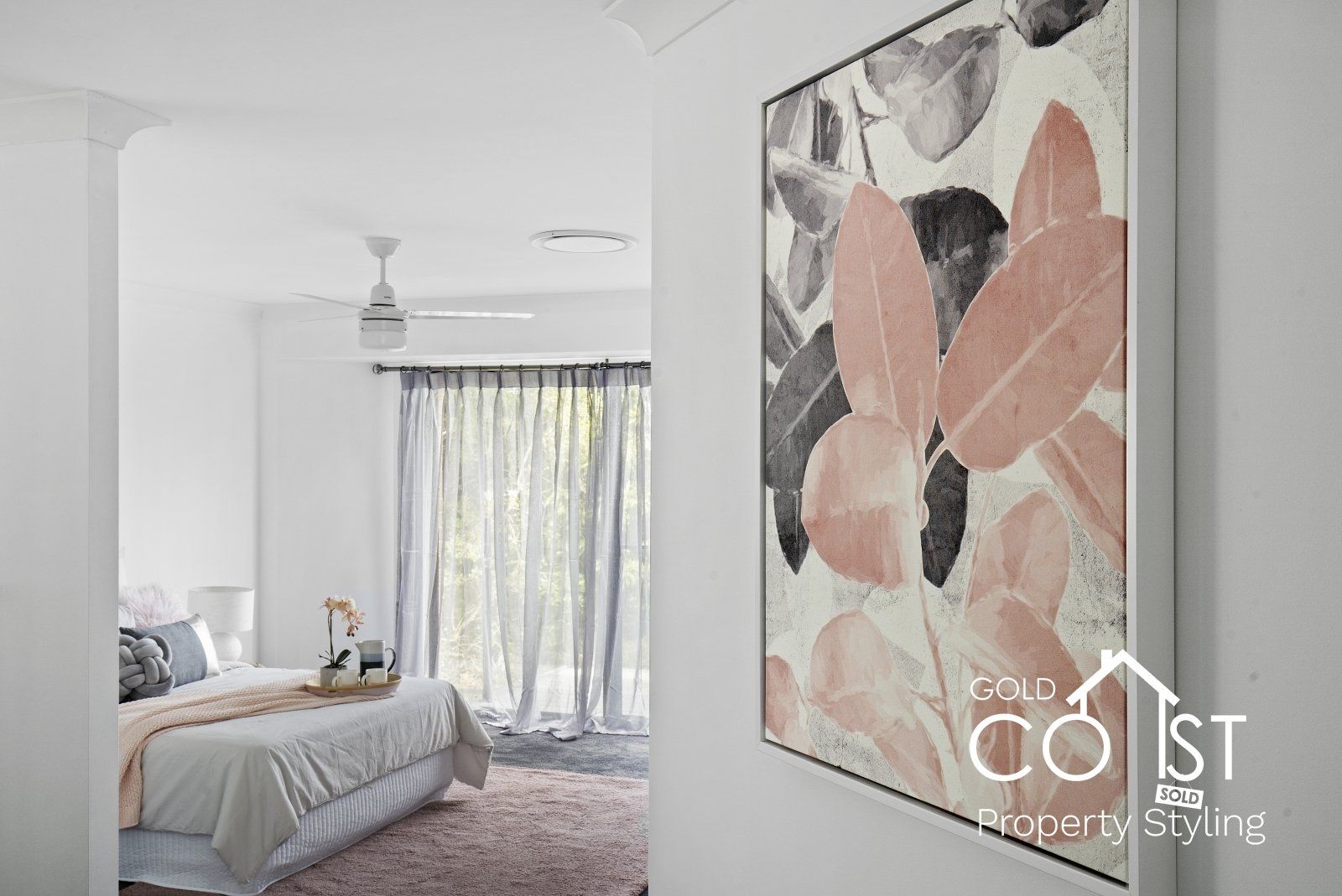 A bedroom with a bed and a painting on the wall.