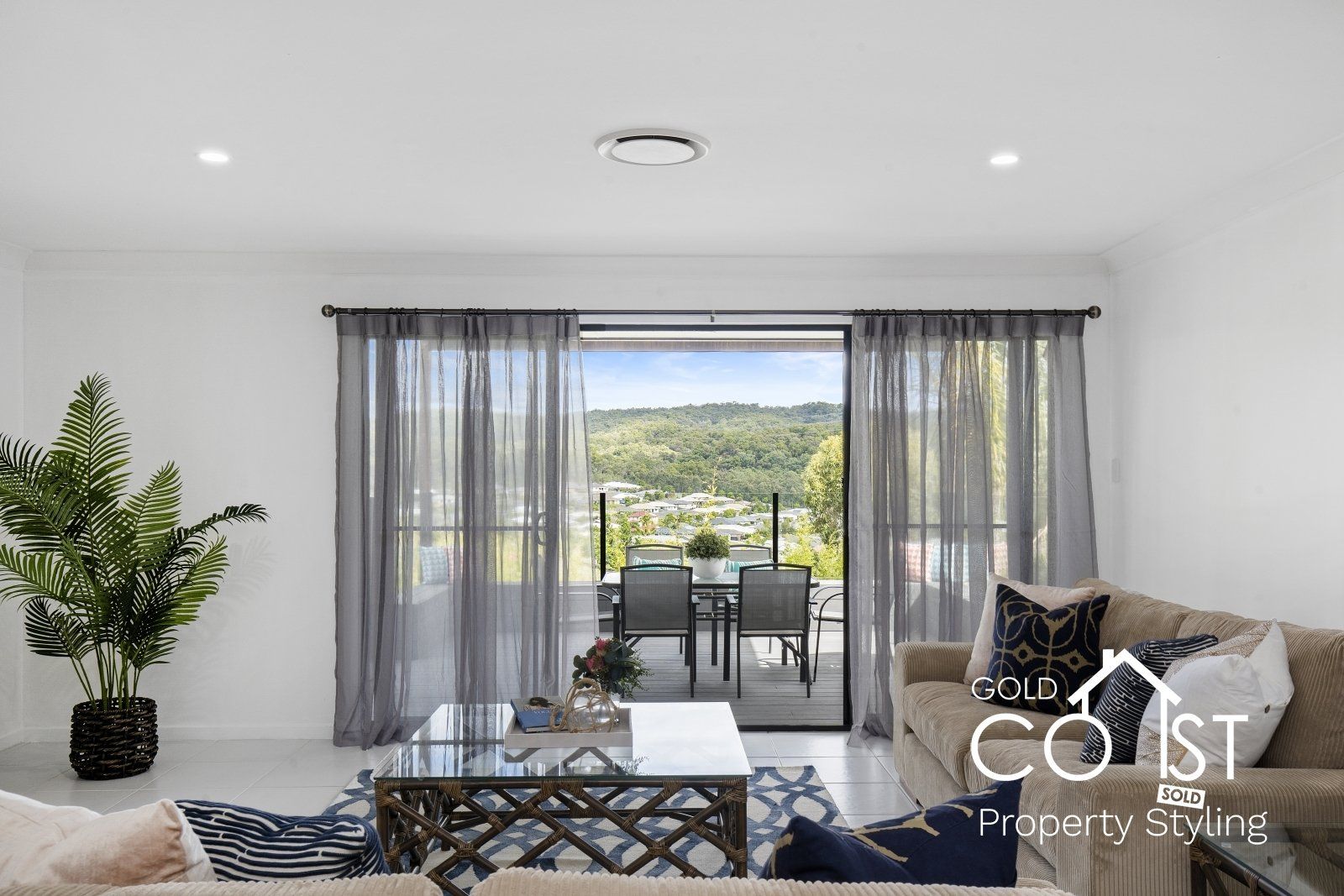 A living room with a couch , coffee table , and sliding glass doors leading to a balcony.