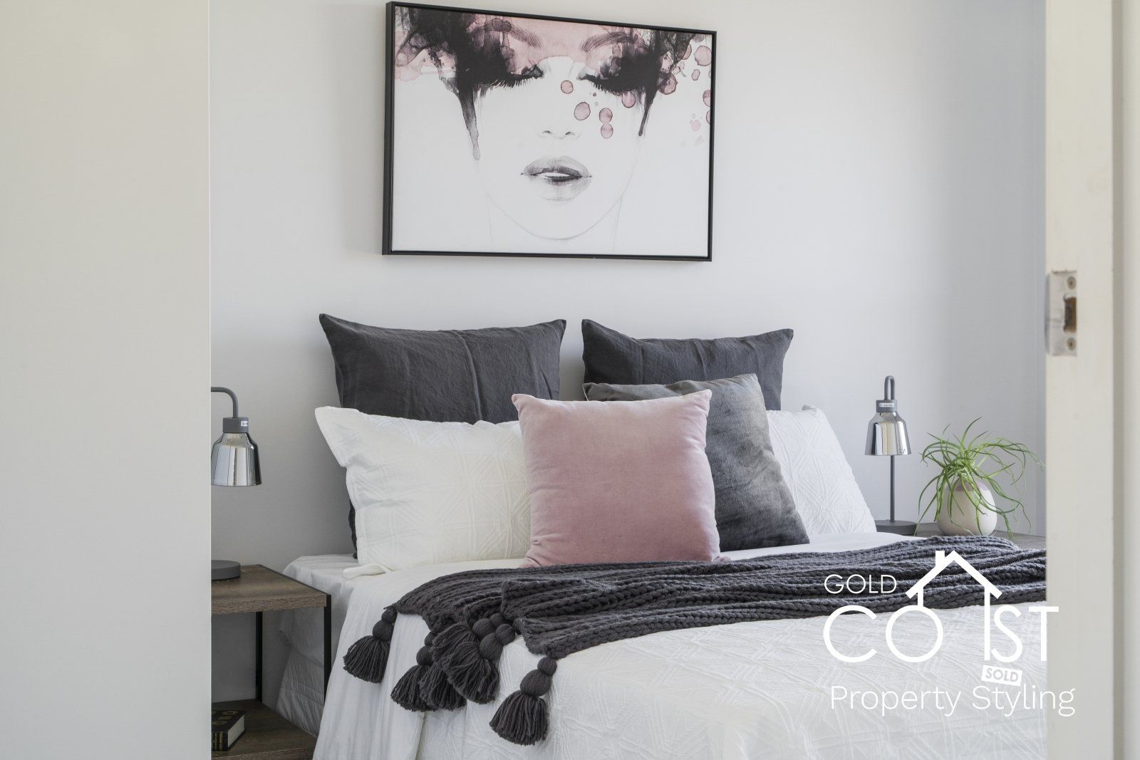 A bedroom with a bed and a painting on the wall above it.