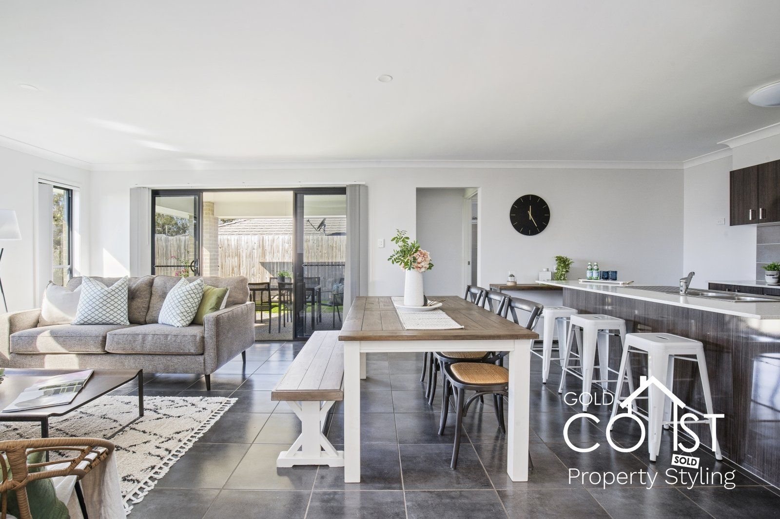 A living room with a couch , table , chairs and a kitchen.