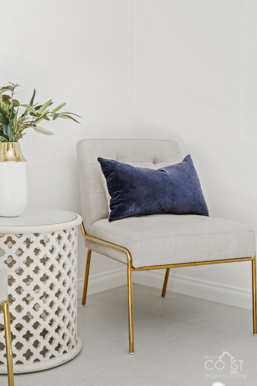 A chair with a blue pillow on it is sitting next to a table.