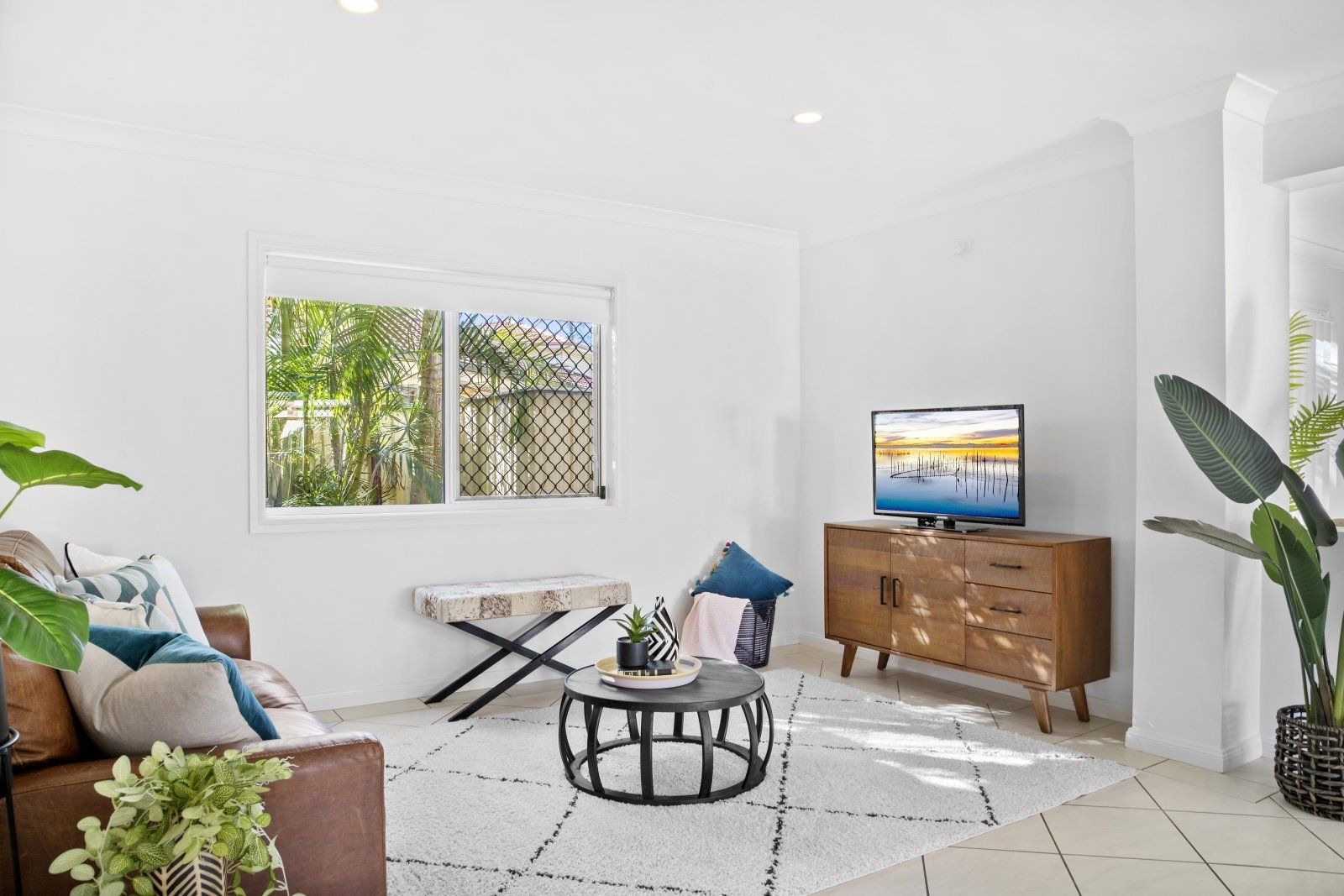 A living room with a couch , coffee table , and television.
