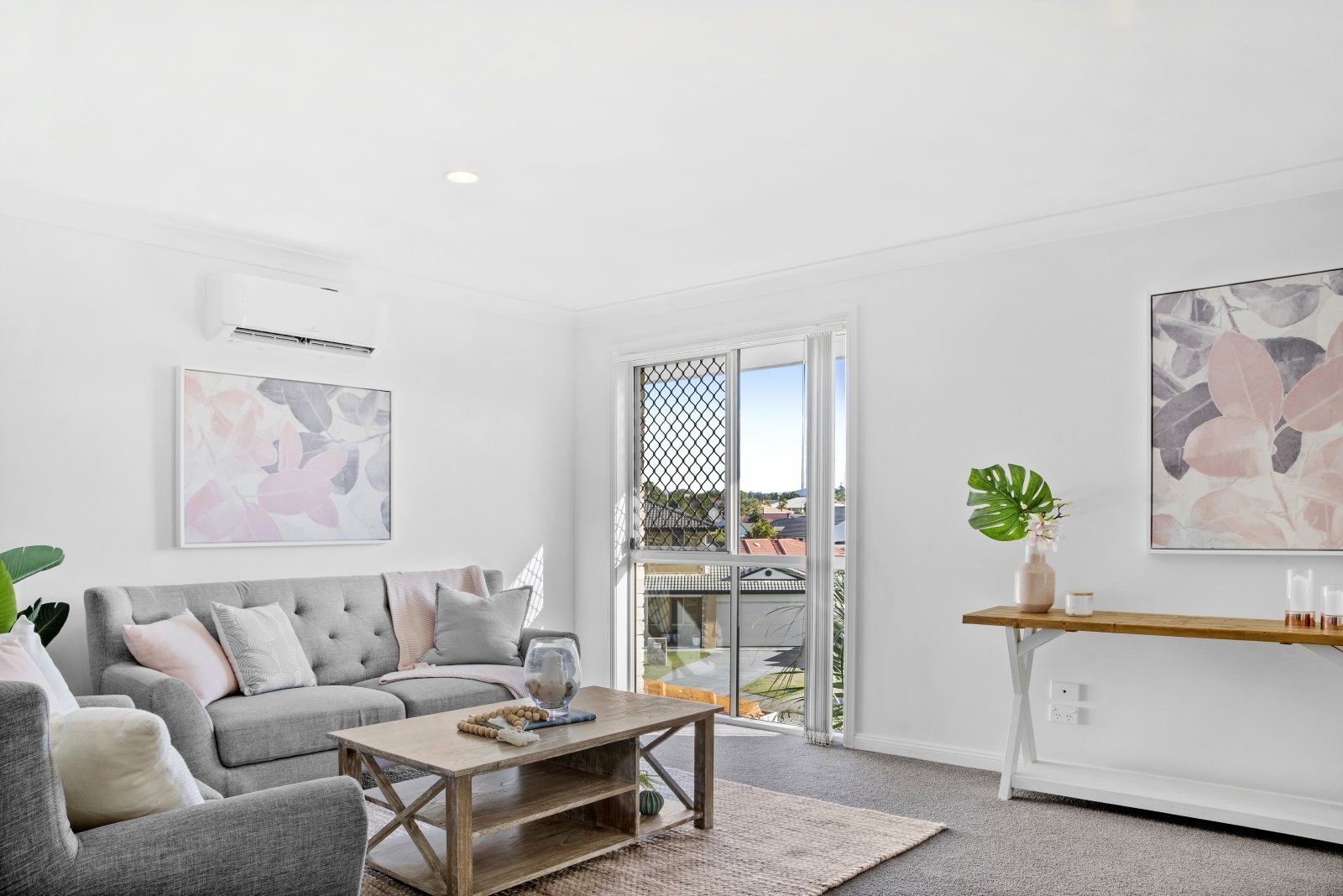 A living room with a couch , chair , coffee table and a painting on the wall.