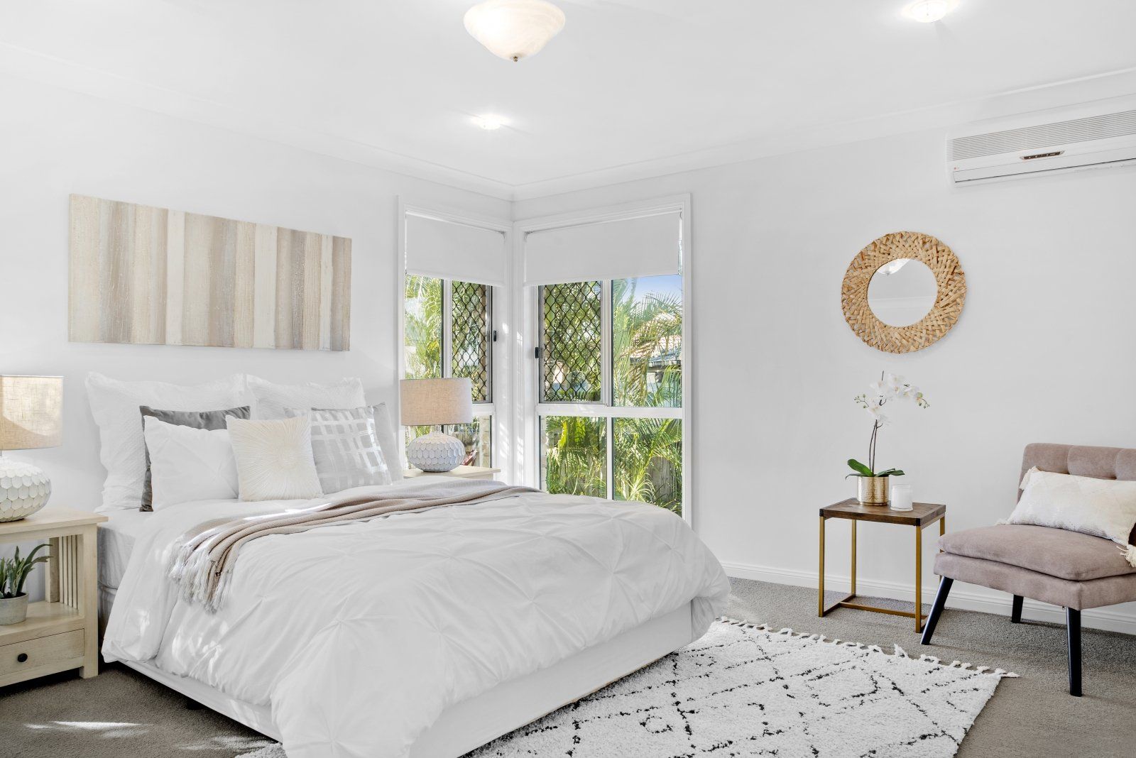 A bedroom with a large bed , chair , nightstand and rug.