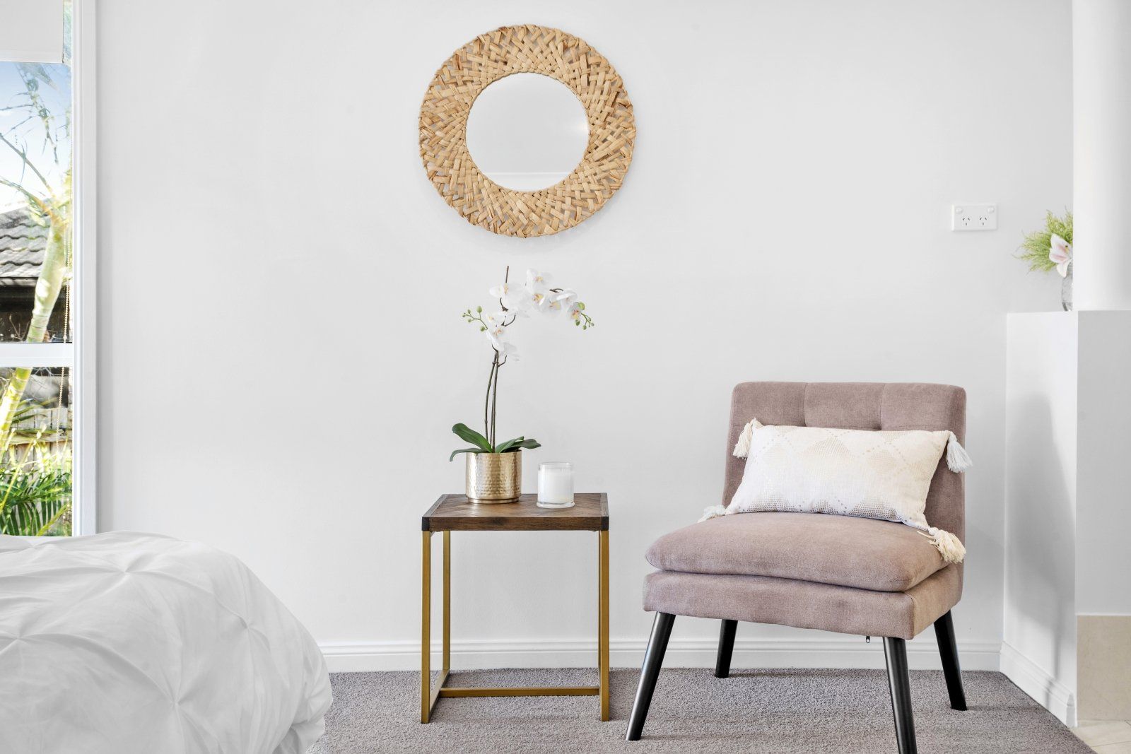 A bedroom with a chair , table and mirror.