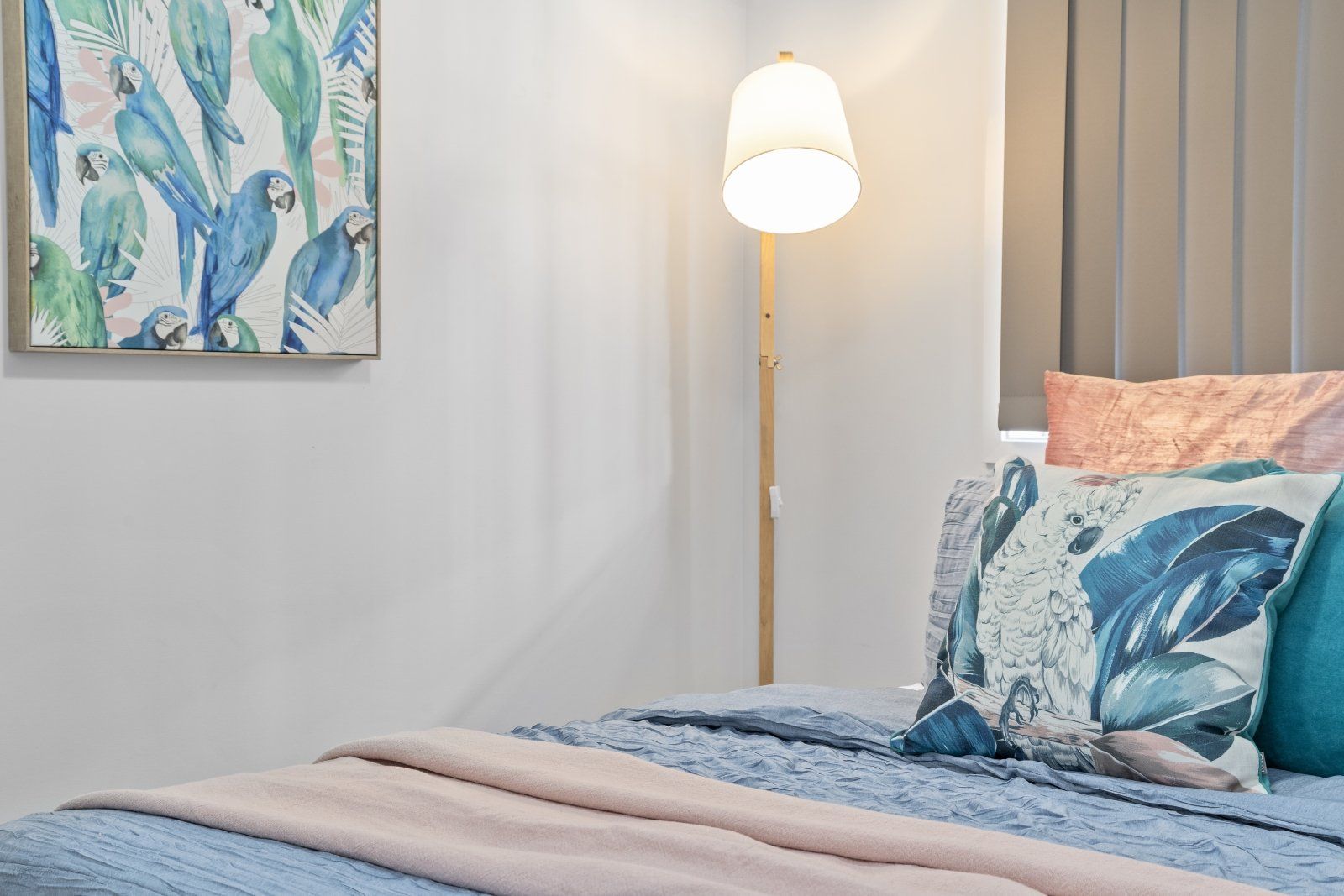 A bedroom with a bed , lamp and painting on the wall.