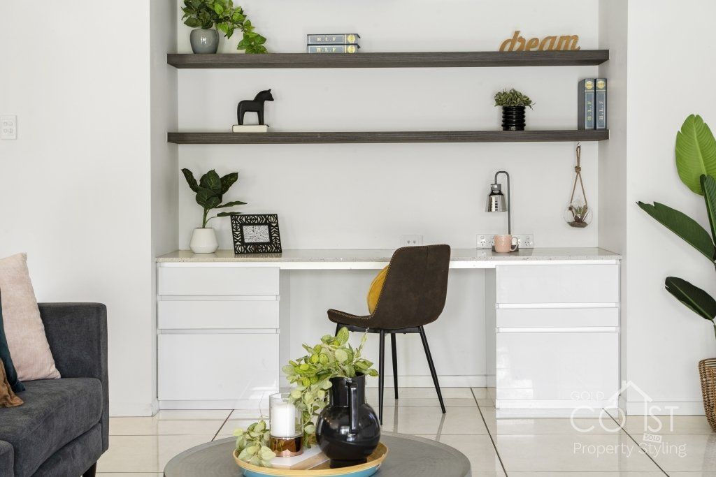 A living room with a desk , chair , couch and coffee table.