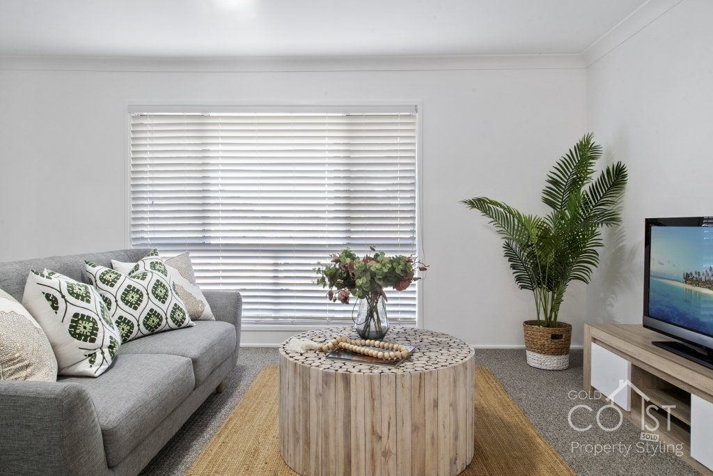 A living room with a couch , coffee table , and television.