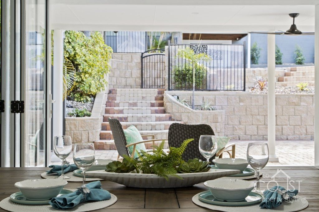 A dining room table with plates , bowls , and glasses on it.