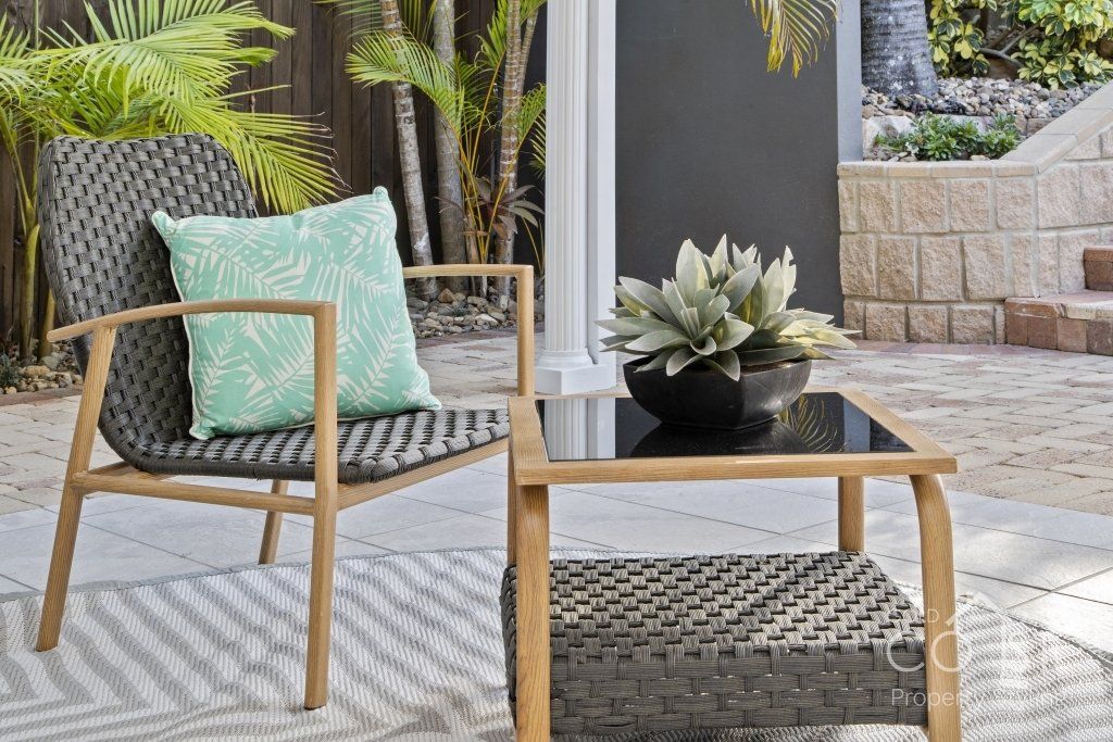 A chair and a table are sitting on a patio.