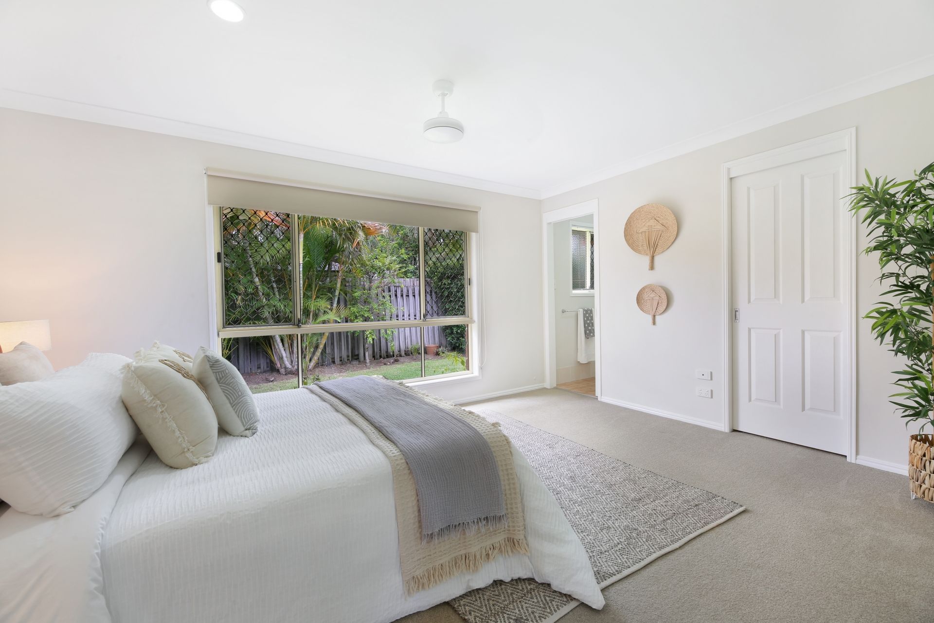 A bedroom with a large bed and a large window.
