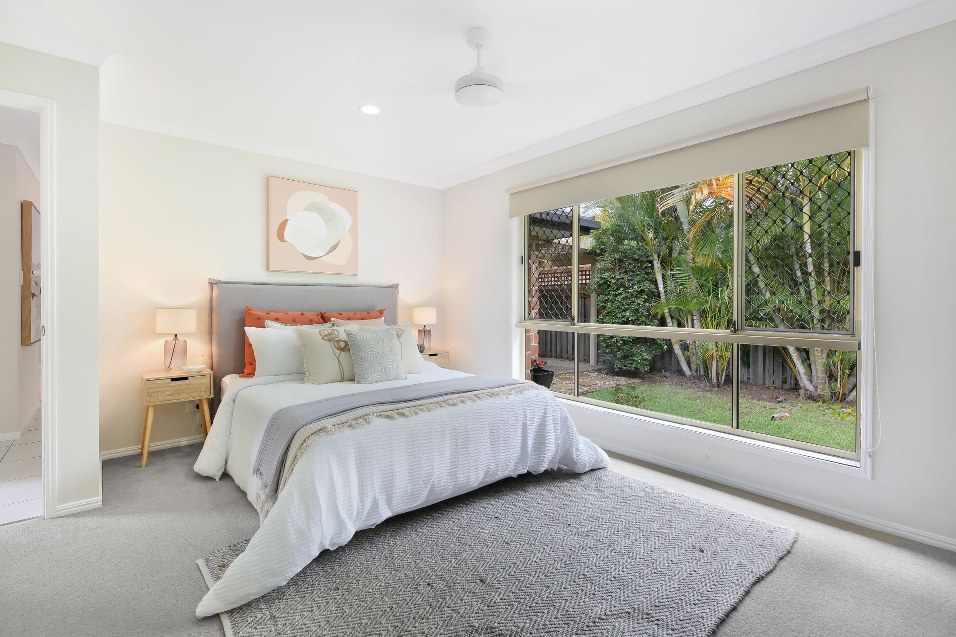 A bedroom with a large bed and a large window.