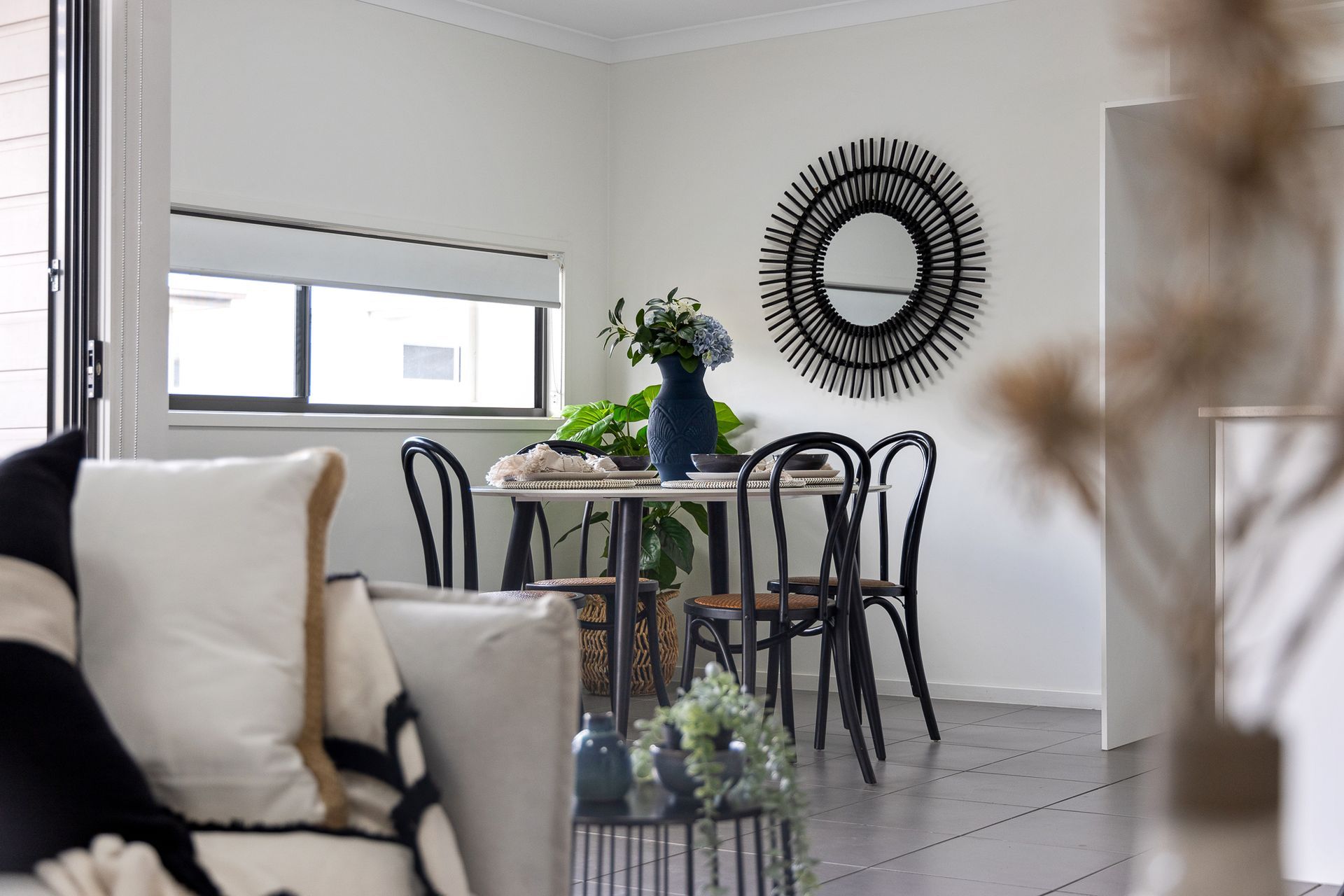 A living room with a table and chairs and a mirror on the wall