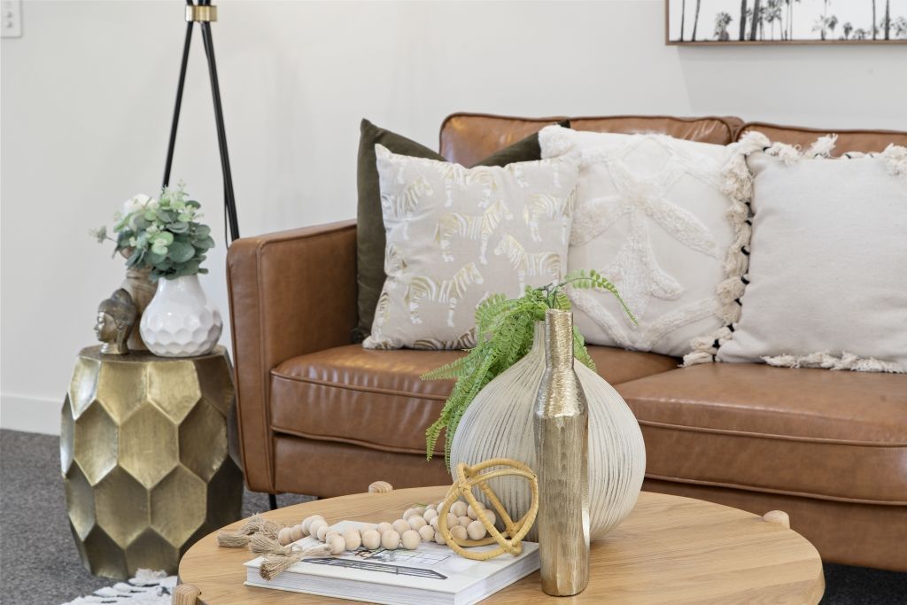 A living room with a brown leather couch and a wooden coffee table.