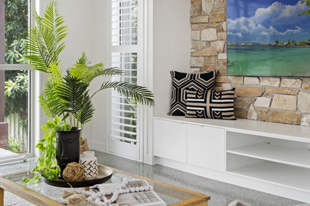 A living room with a coffee table and a painting on the wall.