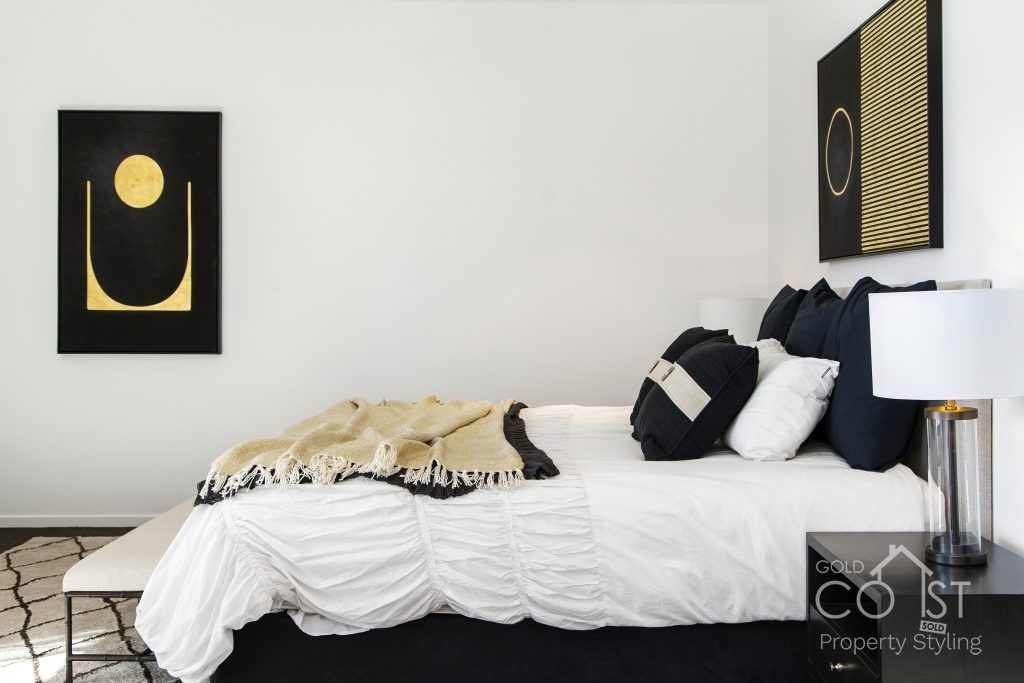 A bedroom with a bed and a painting on the wall.