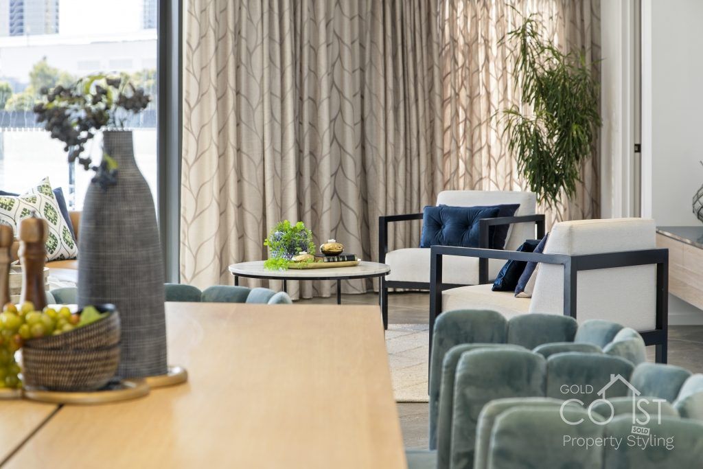 A living room with a table and chairs and a vase of grapes