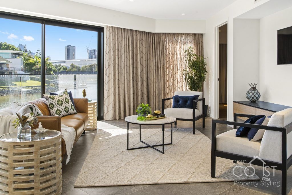 A living room with a couch , chairs , coffee table and television.