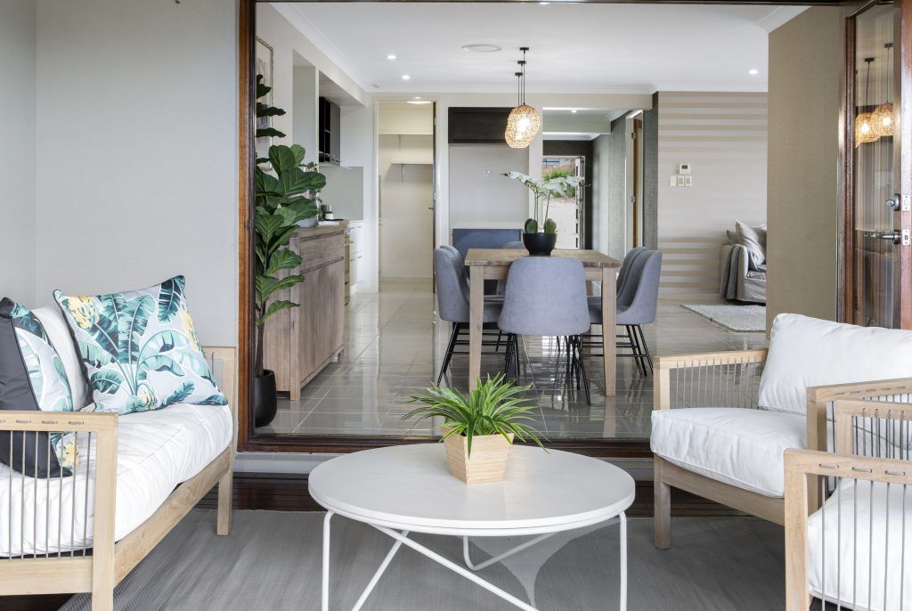 A living room with a couch , chair , coffee table and dining table.