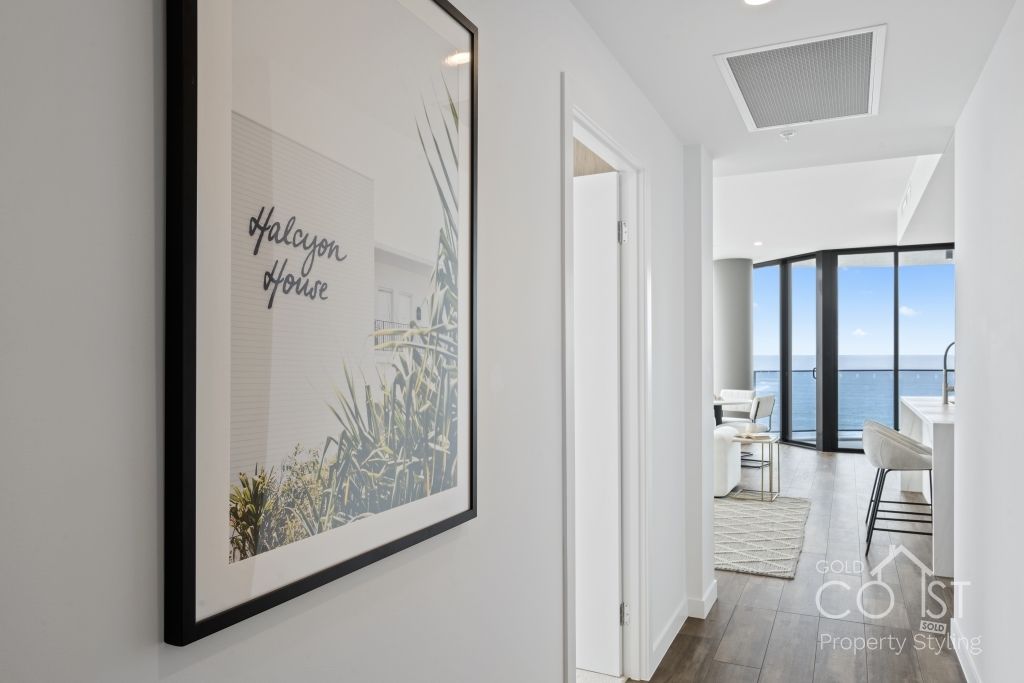 A picture is hanging on a wall in a hallway.