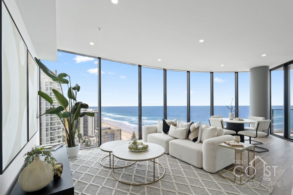 A living room with a lot of windows overlooking the ocean